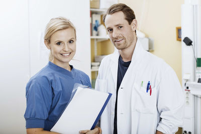 Portrait of confident doctor and nurse with file in hospital