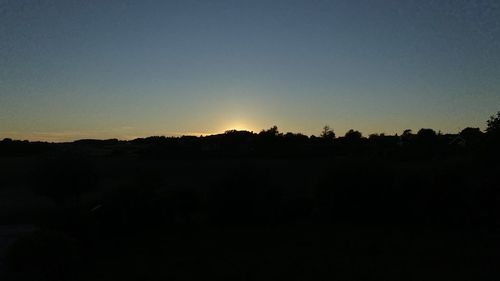 Silhouette landscape against clear sky during sunset