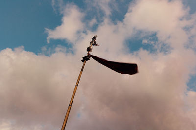 Low angle view of flag against cloudy sky