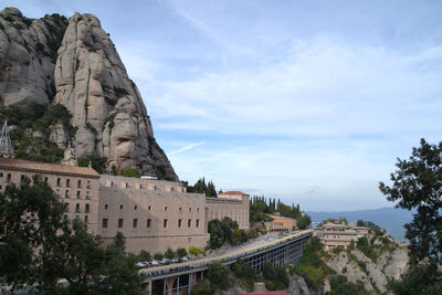 Buildings by mountain against sky