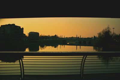 River in city against clear sky during sunset