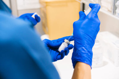 Hands of nurse preparing syringe at medical clinic