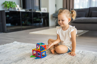 Portrait of cute boy playing with toy blocks at home