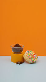 Still life photography of donut cake with rainbow topping and coffe beans