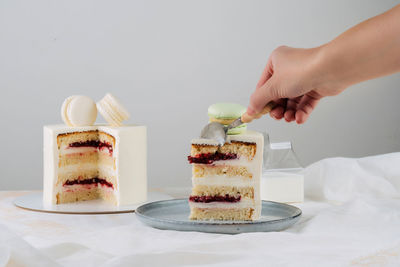 Cropped hand of person preparing food on table