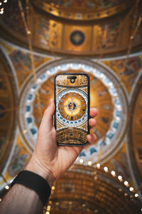 Cropped hand of woman holding clock
