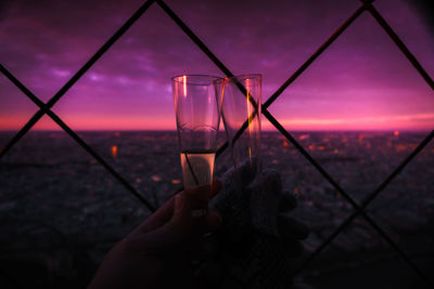 Cropped image of people toasting champagne flutes against sky at twilight