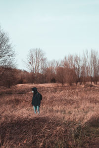 Rear view of man walking on field