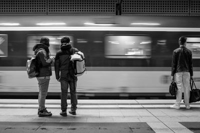 Men waiting at railroad station platform