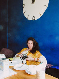 Portrait of young woman sitting on table