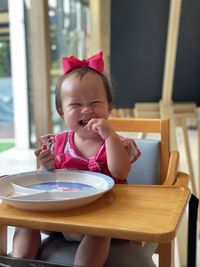 Portrait of cute girl playing and smiling in cafe