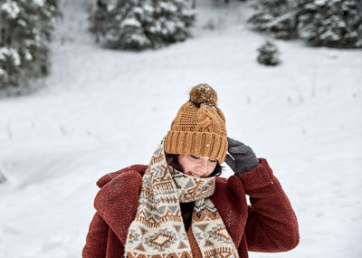 Winter portrait of a young woman. snow, outdoors, knitted cap, scarf.