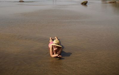 High angle view of woman lying on sand at beach