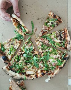 High angle view of hand holding pizza