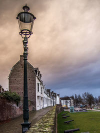 Street light by building against sky, maastricht 