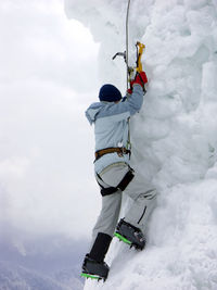 Low angle view of person climbing on snow