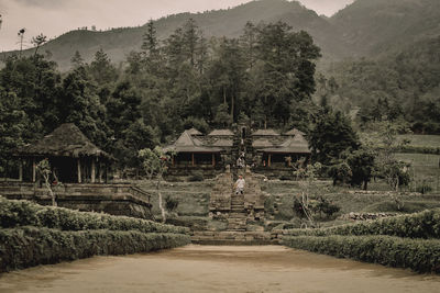 Gazebo amidst trees and buildings against sky