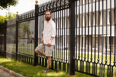 Full length of man standing by fence