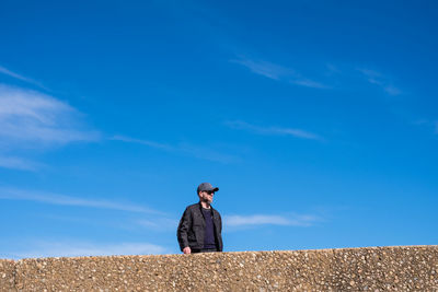 Man standing against blue sky