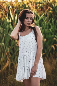 Young woman standing against plants