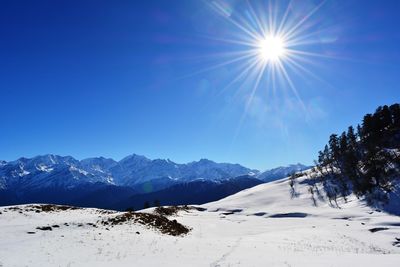Scenic view of snowcapped mountains against blue sky
