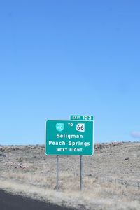 Information sign in desert against clear blue sky