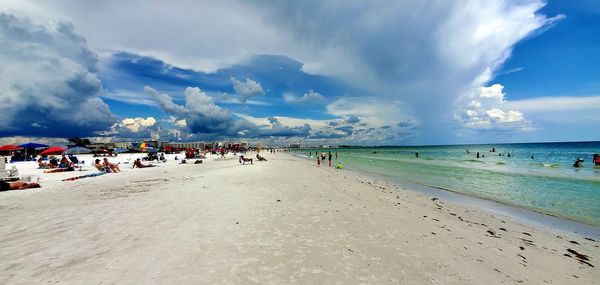 Group of people on beach against sky