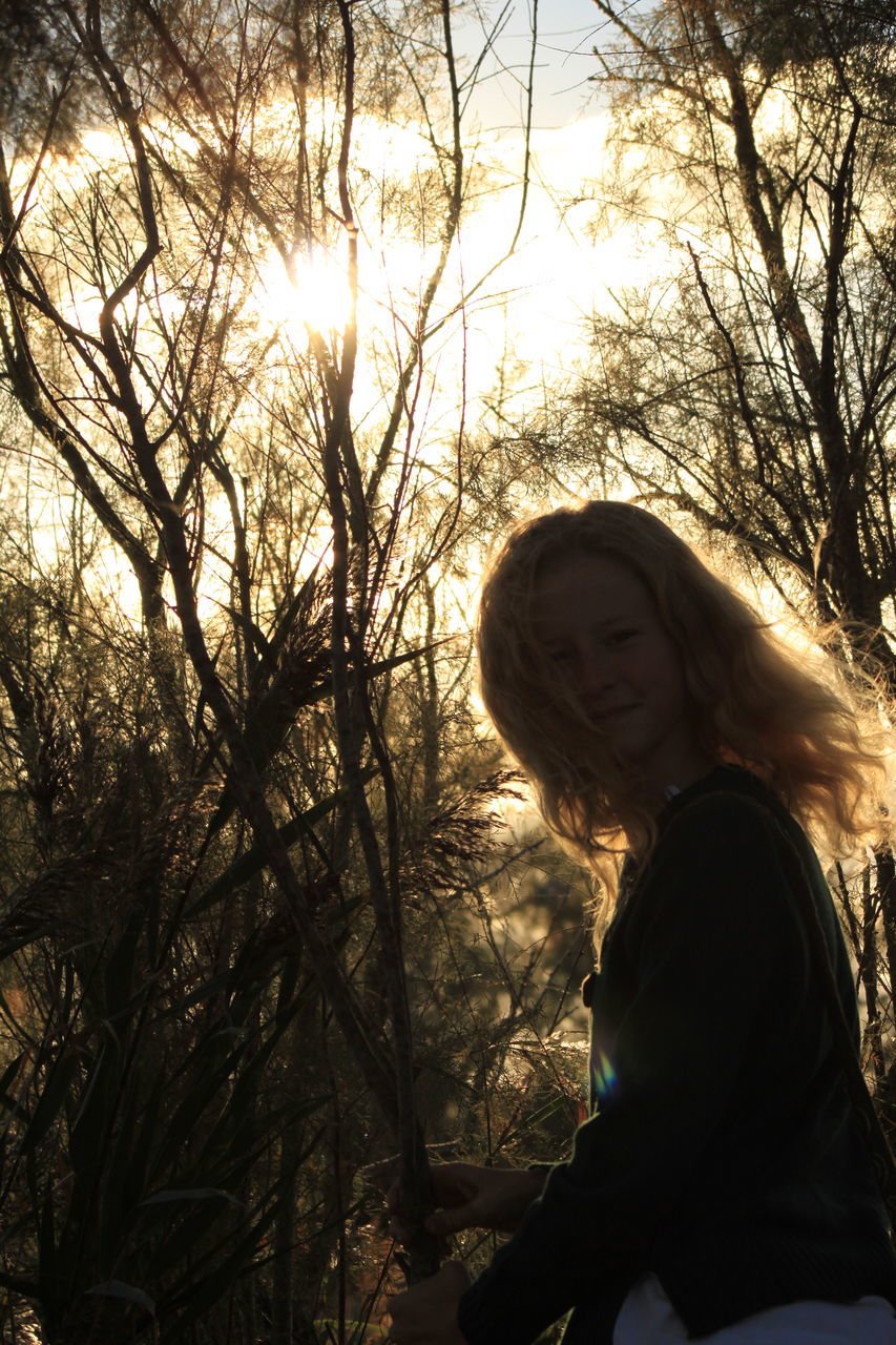 LOW ANGLE VIEW OF WOMAN ON TREE AGAINST SKY