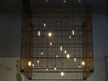 Low angle view of illuminated lights hanging on ceiling in building