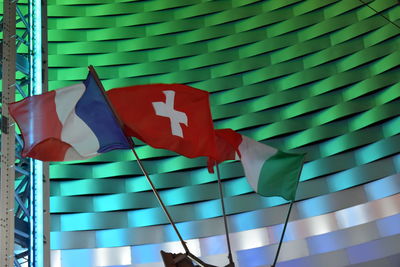 Close-up of flags against blue wall