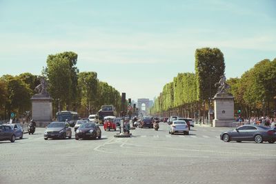 Traffic on street at arc de triomphe against sky