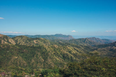 Scenic view of mountains against blue sky