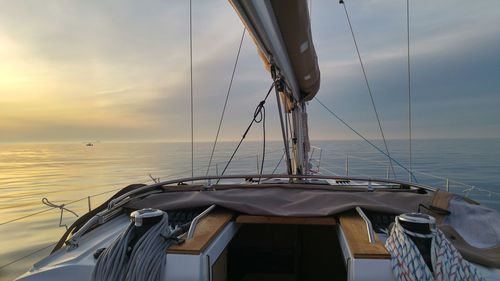 Sailboat sailing on sea against sky during sunset