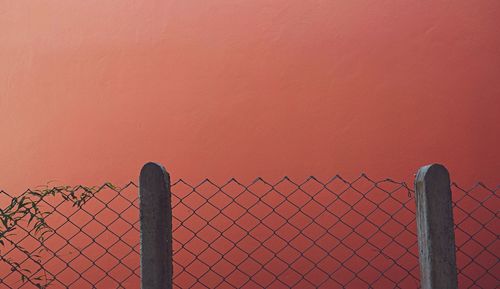 Chainlink fence against clear sky during sunset