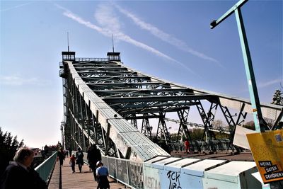 People walking on bridge against sky