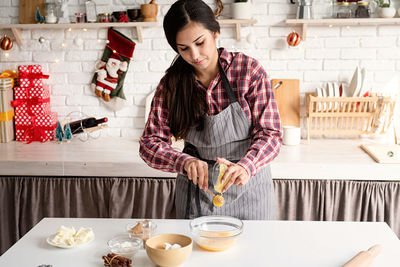 Midsection of woman holding food on table at home