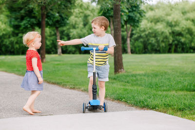 Full length of cute sibling standing on road