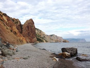 Rock formations by sea against sky