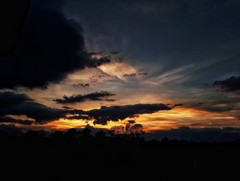 Scenic view of dramatic sky over silhouette landscape