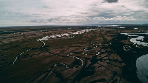 Aerial view of land and sea against sky