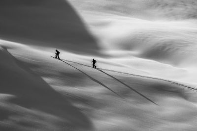 People skiing on snowcapped mountain against sky