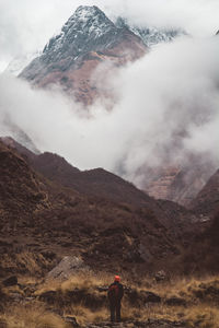 Man walking on field against volcanic mountains