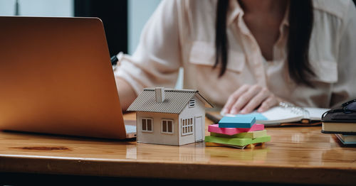 Midsection of businesswoman using laptop on table