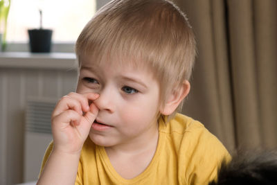 Child boy baby with finger in his nose. 3 years old kid picking his nose.  early age children 