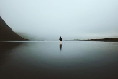 Man in sea against sky