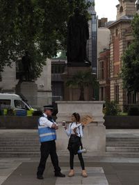 Full length of woman walking by building in city