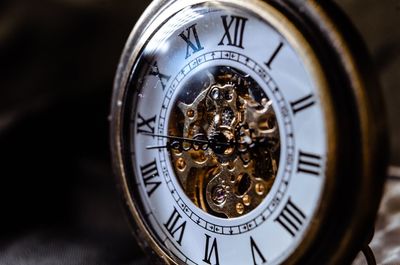 Close-up of pocket watch against black background