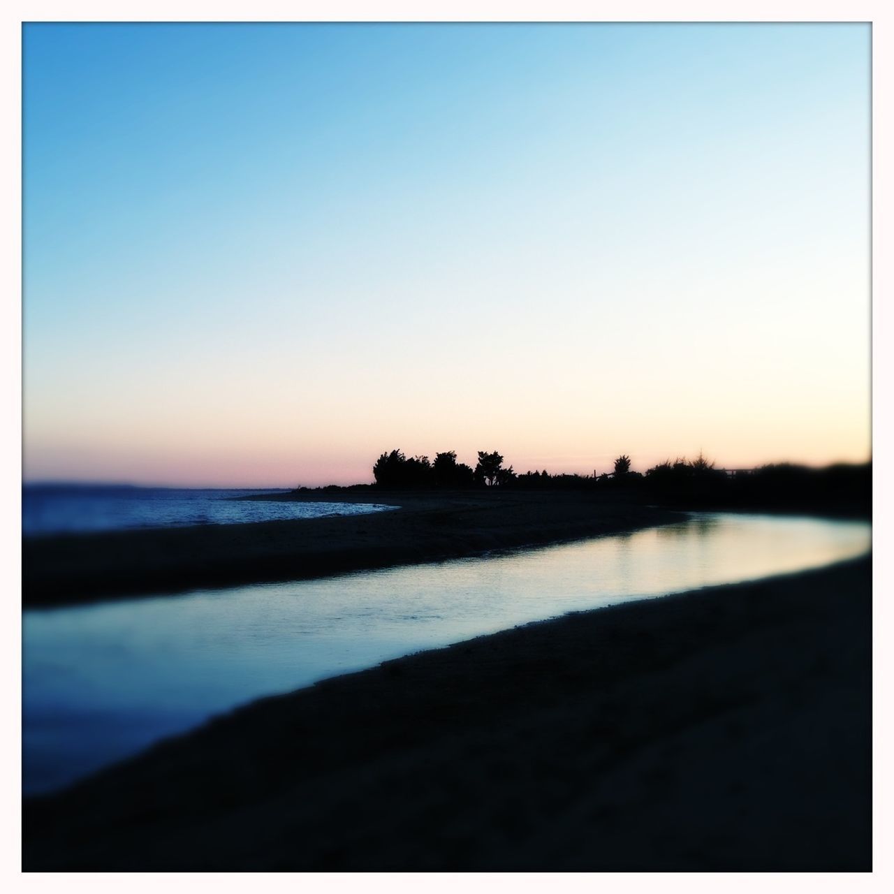 clear sky, water, copy space, transfer print, sea, tranquil scene, sunset, tranquility, scenics, auto post production filter, beauty in nature, beach, horizon over water, silhouette, nature, shore, idyllic, calm, reflection, outdoors