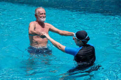 Full length of shirtless man swimming in pool