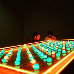 Men sitting by illuminated lights in room